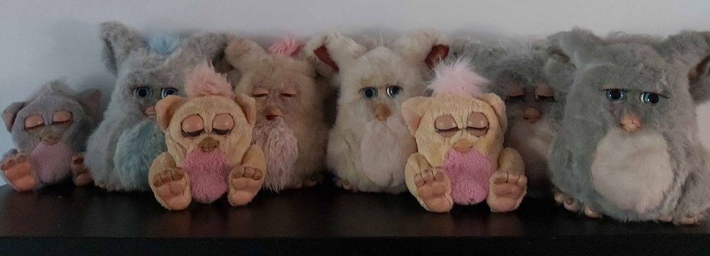 A group of five full-size 2005 emototronic Furbys and three 2025 baby Furbys.