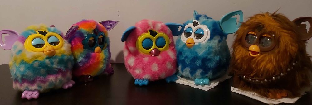 A pink and a blue Furby boom!, an Easter Furby boom! and a rainbow crystal Furby boom!, and a Chewbacca Furby boom! A couple of them are sitting on paper towel because they have battery leakage out their butts, awkward...